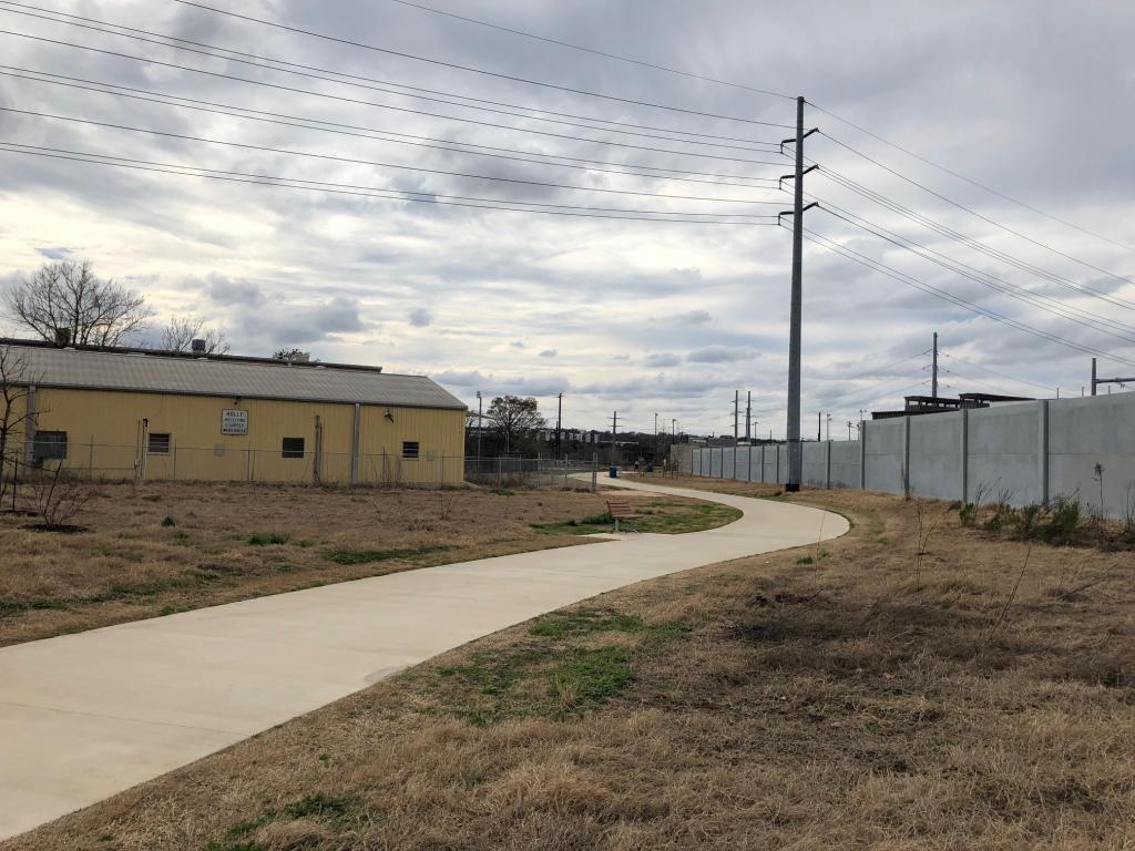 Image of trail between wall and building of old Holly Power Plant